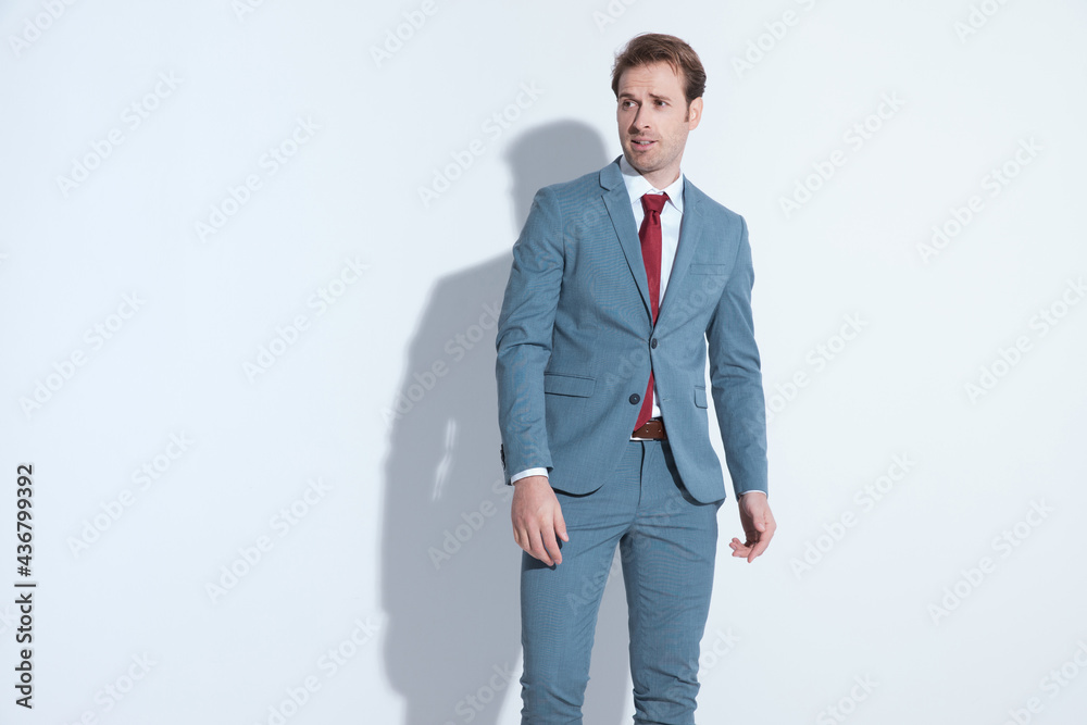 sexy unshaved businessman in blue suit looking to side