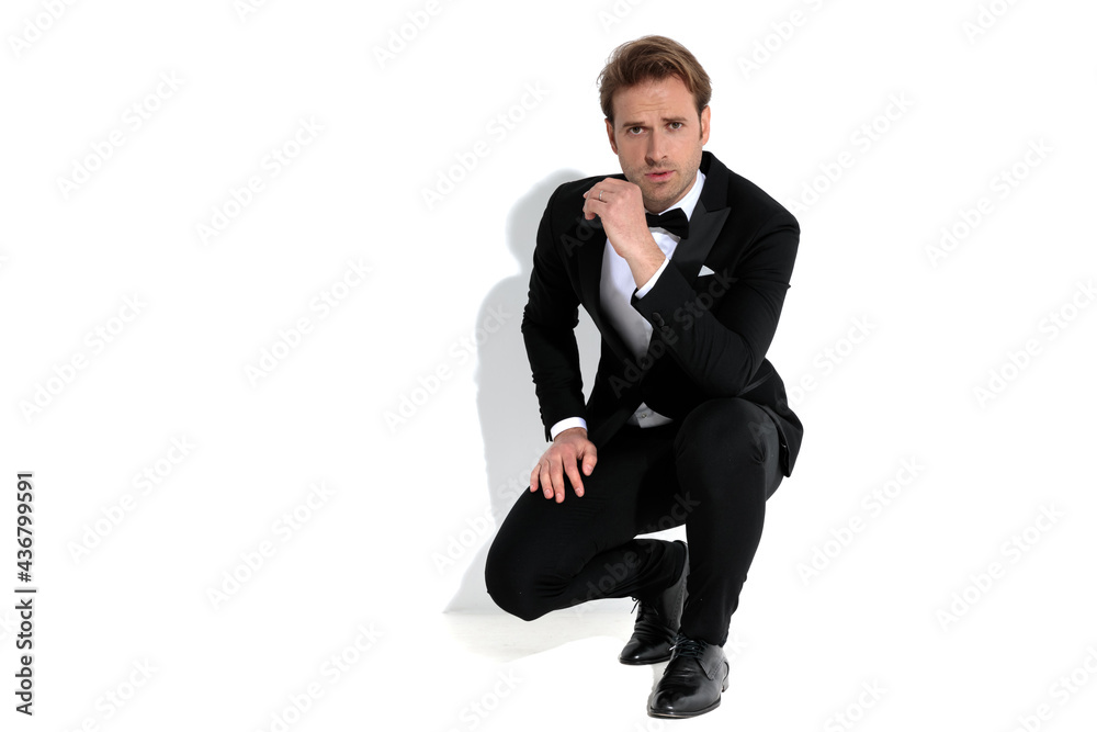 sexy businessman slouching, resting his arm on his lap sexy businessman slouching, resting his arm on his lap
