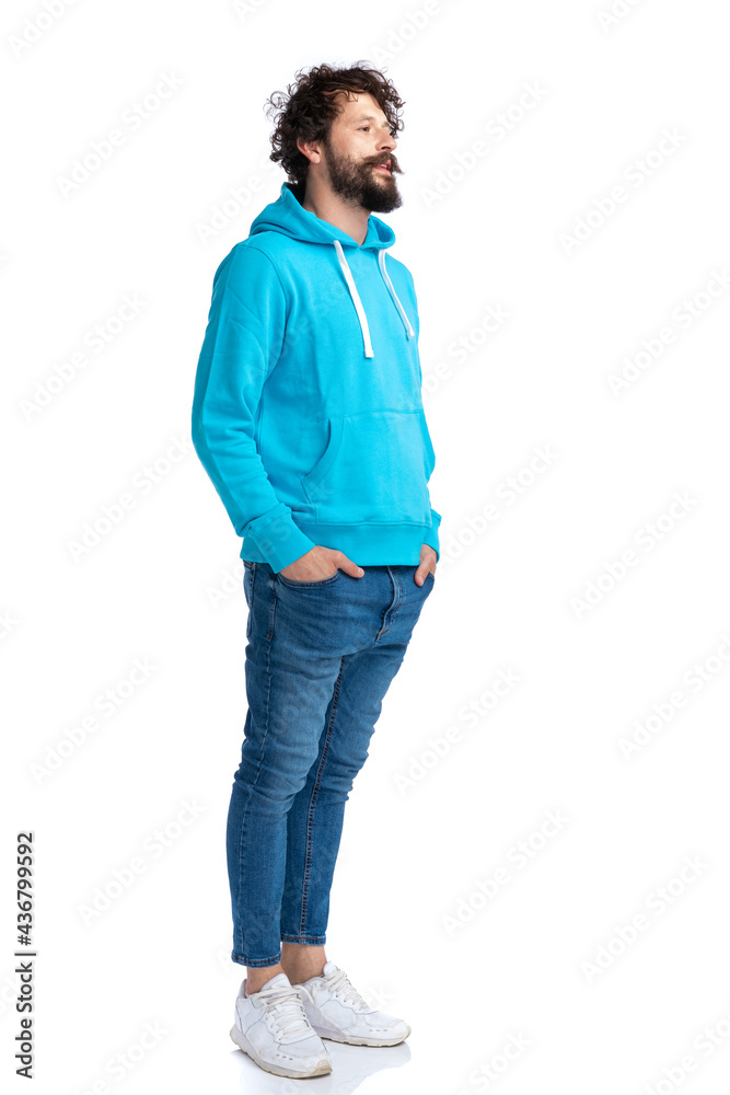 cool bearded guy in blue hoodie holding hands in pockets and waiting cool bearded guy in blue hoodie holding hands in pockets and waiting