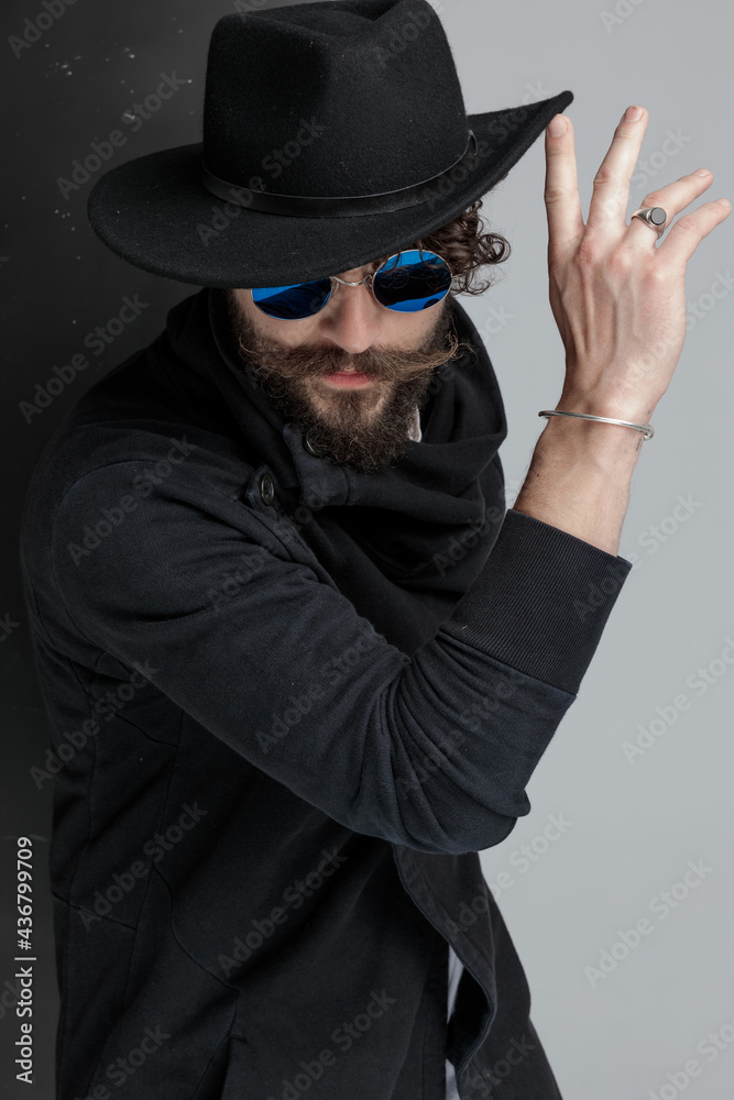 mysterious lating fashion model pushing hat up and posing mysterious lating fashion model pushing hat up and posing