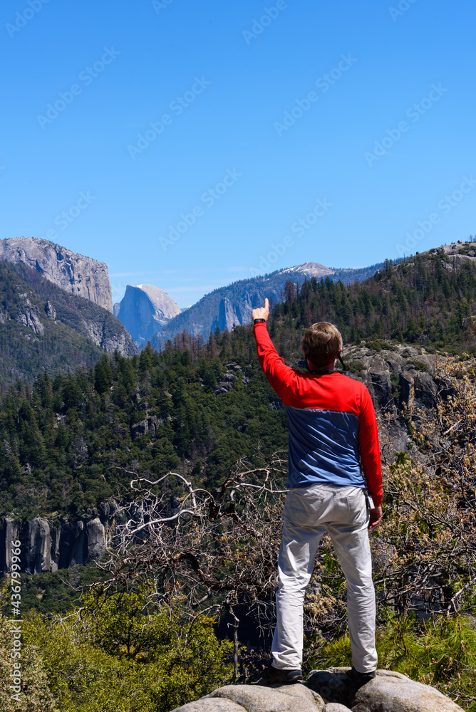 Tourist pointing at Half Dome, Hiking in Yosemite National Park Tourist pointing at Half Dome, Hiking in Yosemite National Park