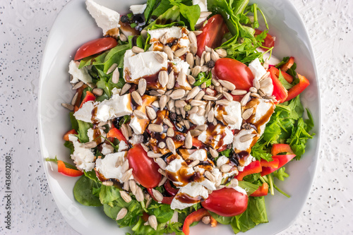 Fresh vegetables salad with feta cheese and roasted sunflower seeds, top view