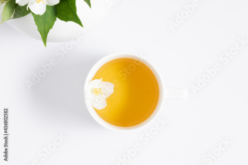 Jasmine tea and jasmine flowers.Teapot with jasmine flowers on white background. Flat lay, top view, copy space