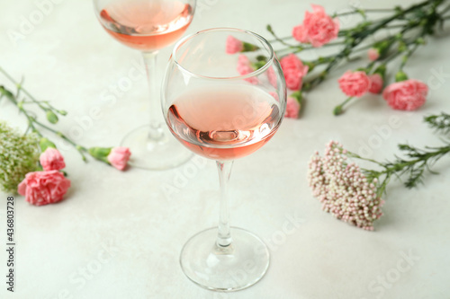 Fototapeta Naklejka Na Ścianę i Meble -  Glasses of pink wine and beautiful flowers