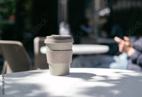 Eco bamboo coffee cup on the background of the cafe. eco-concept photo