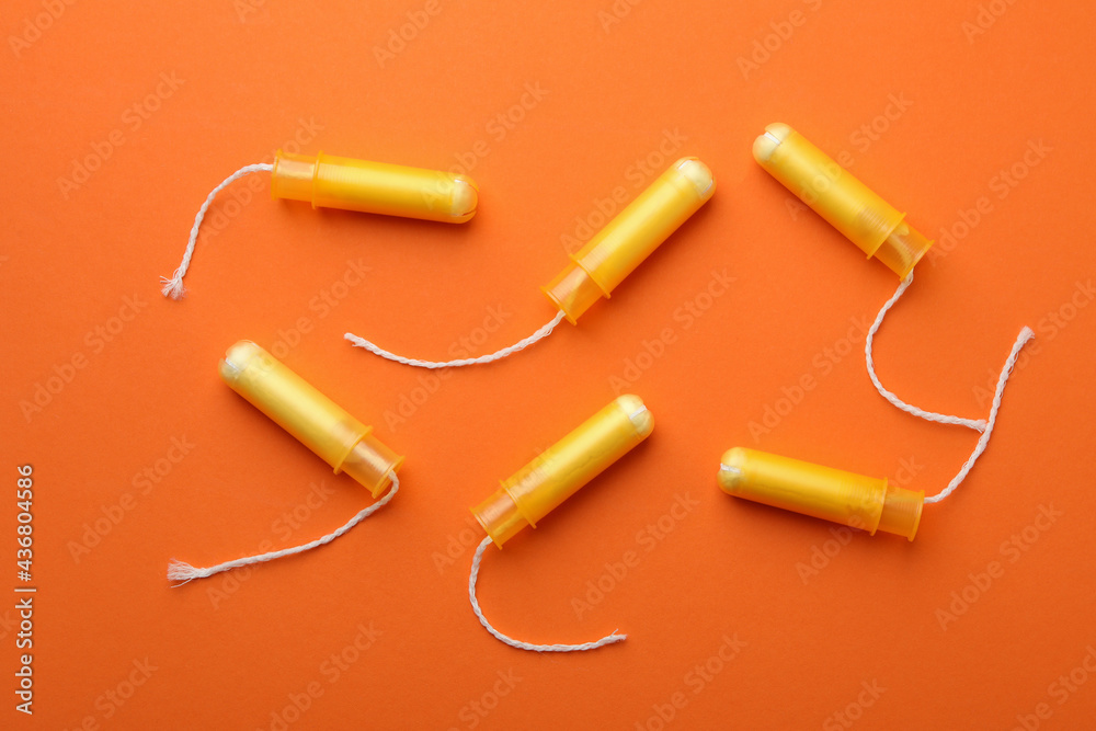Women tampons on orange background, top view Women tampons on orange background, top view