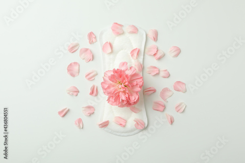 Hygiene pad with flower and petals on white background photo