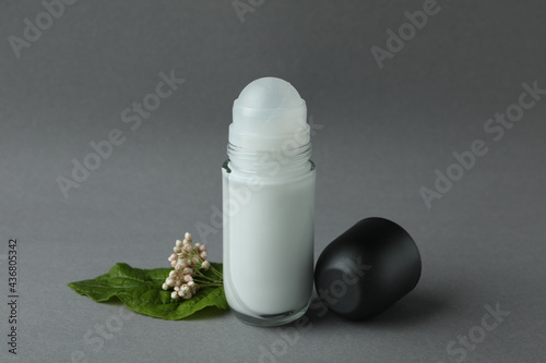 Blank deodorant and flower on gray background