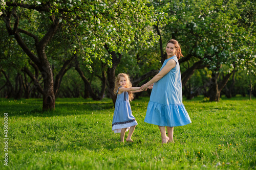nature scene with family outdoor lifestyle. Mother and little daughter playing together in a park. Happy family concept. Happiness and harmony in family life.