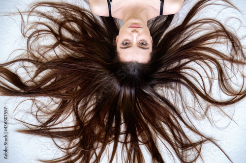 Foto Beautiful young woman lying on the white background with long widespread sprawle