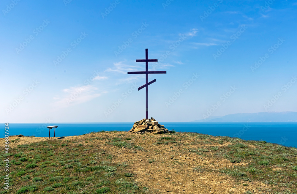 Orthodox cross on the top of the coastal mountain. Crimea.