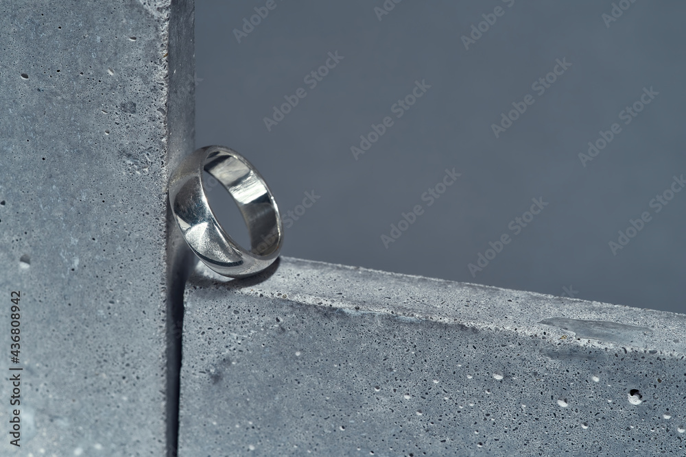 Closeup shot of silver ring on concrete element isolated over gray background Closeup shot of silver ring on concrete element isolated over gray background