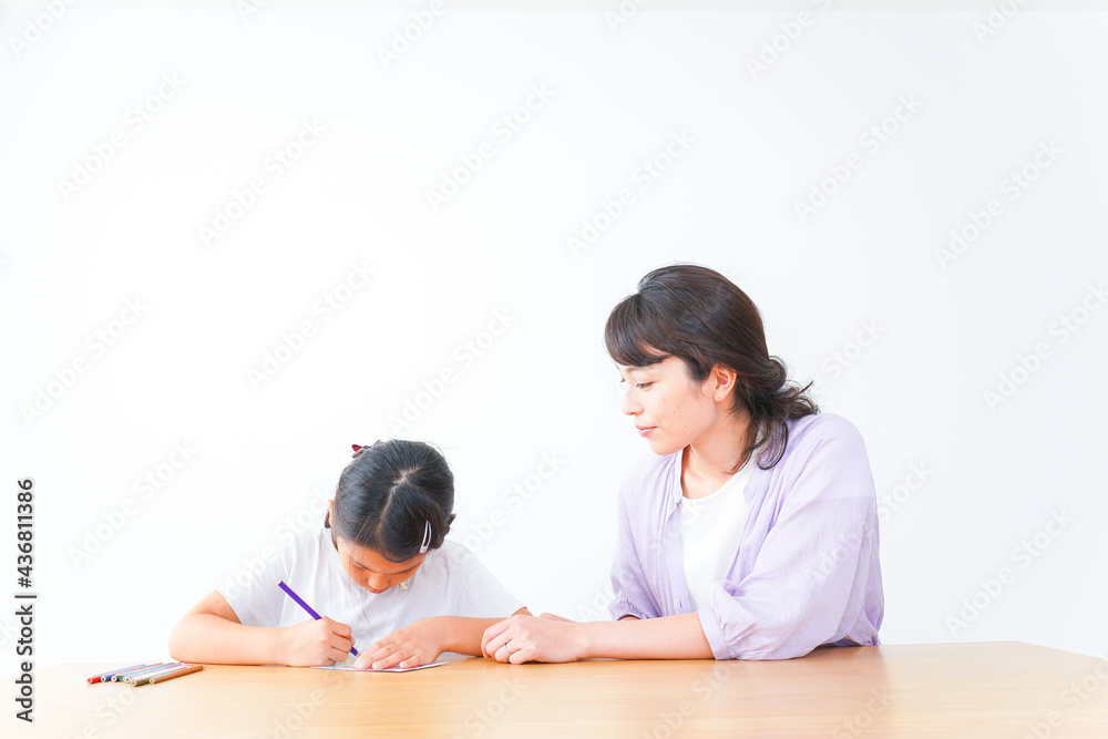 お家でお母さんとお勉強する女の子