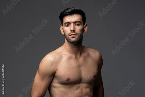 Sexy handsome shirtless man in isolated gray studio background © Atstock Productions