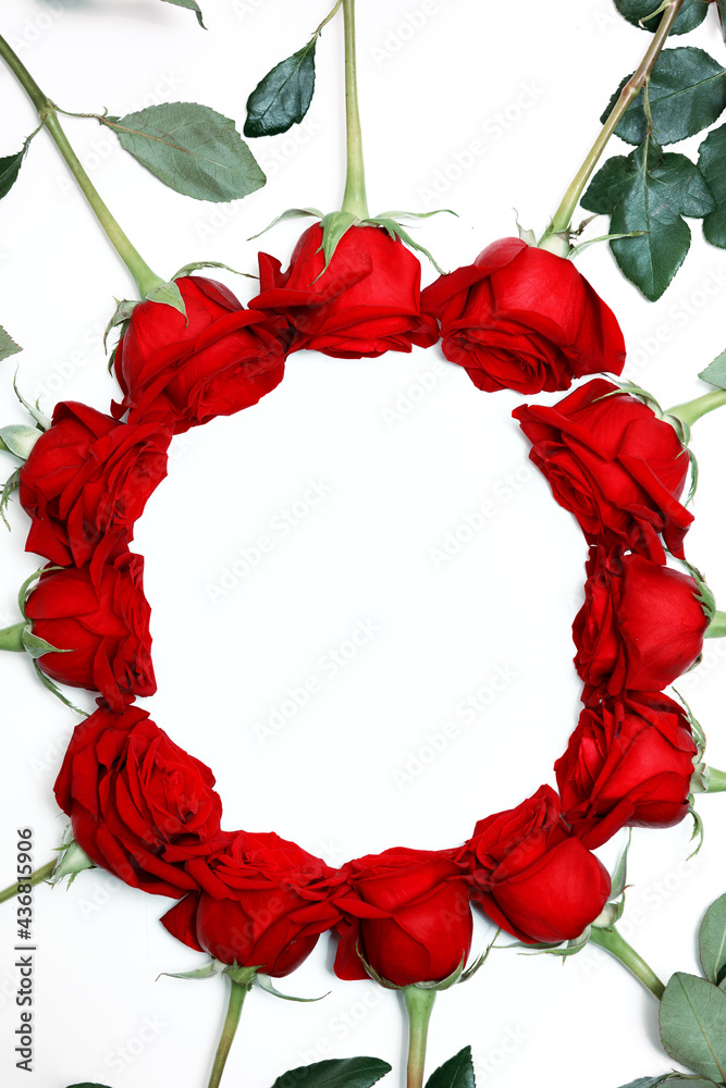 Fototapeta premium Frame of red roses on a white background with space for text. Top view, flat lay. Valentine decoration.