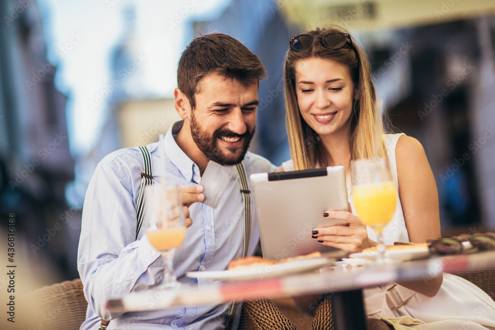 Young couple buying online with credit card and tablet in a coffee shop. Young couple buying online with credit card and tablet in a coffee shop.