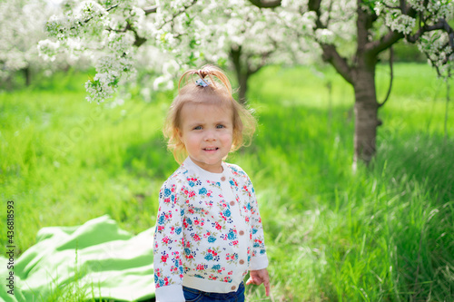 little girl stands in a flowering spring garden. seasonal allergies in children © andrey