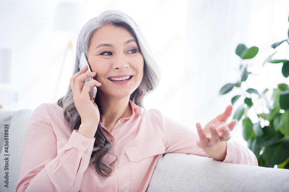 Photo of dreamy happy old woman talk phone good mood smile sit sofa indoors inside house home apartment Photo of dreamy happy old woman talk phone good mood smile sit sofa indoors inside house home apartment