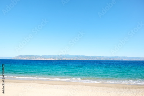 Sandy beach in Messina with views of Calabria and the Messina strait. Tourist season on the mediterranean sea. Sicily. Ionian sea. © Caterina Trimarchi