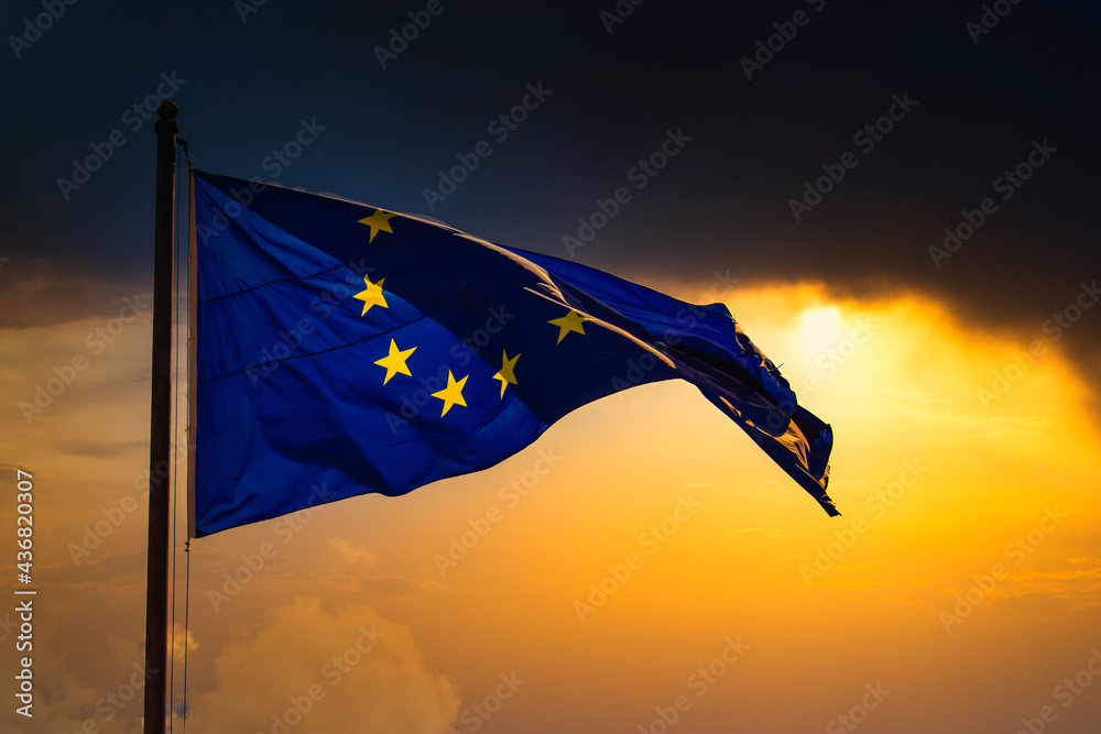 The European Union (EU) flag flies in the wind at sunset