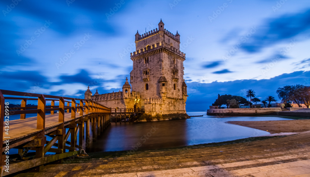 Long exposure of the belen tower in lisbon, portugal. Medieval fortified tower on the Tagus river, at night. Blue and orange colour.
