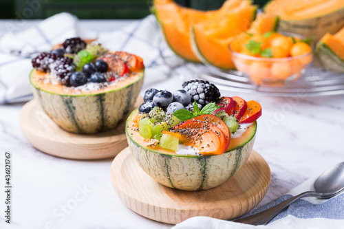 Fruit salad with yogurt in carved melon cantaloupe bowl photo
