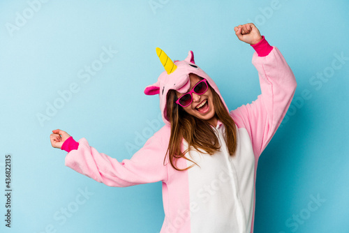Foto Young woman wearing an unicorn costume with sunglasses isolated