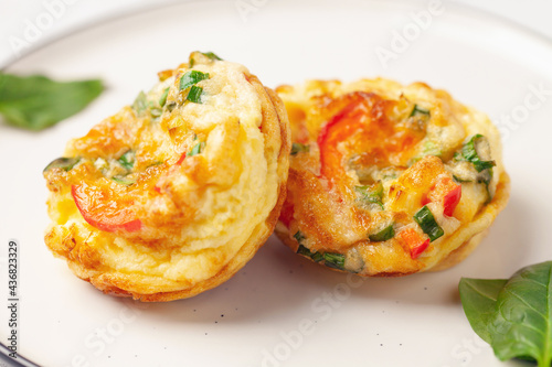 Egg muffins ( bites) and spinach leaves in a plate on a gray background