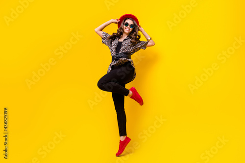 Full body photo of happy nice pretty young woman wear red hat shoes smile isolated on shine yellow color background