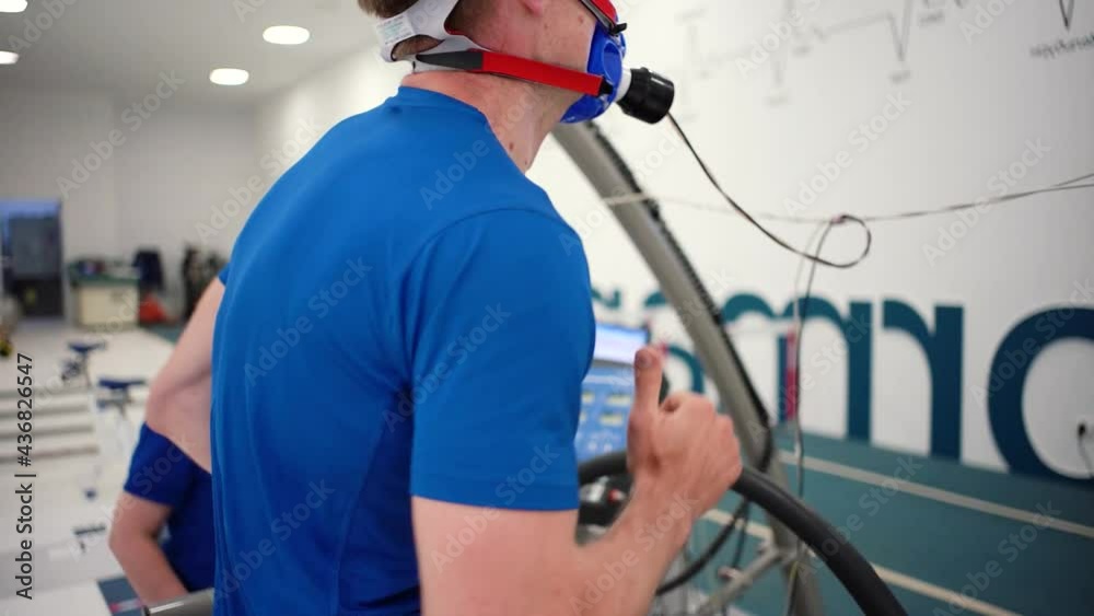 Man athlete going trough the Vo2 Max testing on treadmill in modern sport science lab. triathlete workout testing endurance preparing to the race. Professional sport analyzing