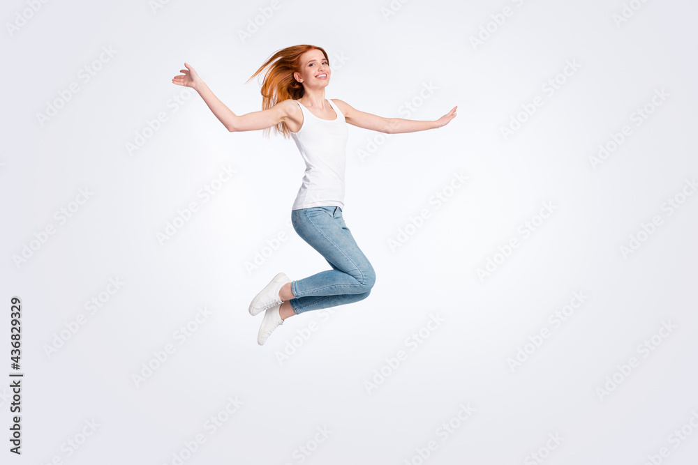Full body photo of funky cheerful red hairdo lady jump wear white top jeans isolated on bright color background