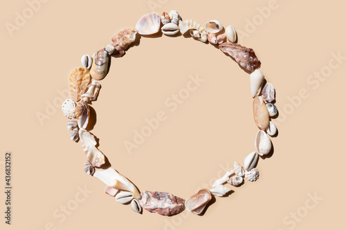 Canvas Print round frame made of sea shells on a beige background
