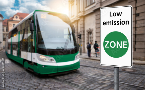 Road sign "Low emission ZONE" on a background of green tramway. Clean mobility concept	