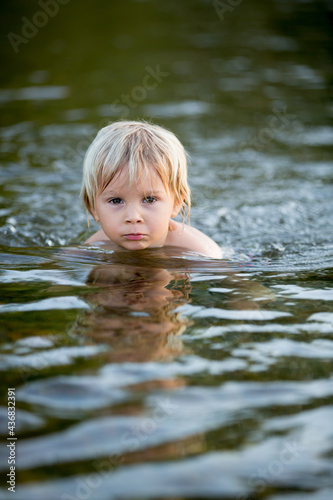 Fototapeta Naklejka Na Ścianę i Meble -  Beautiful portrait of children in lake, kids playing in the water on sunset, summer