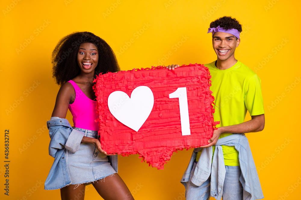 Photo of cute excited young people wear jeans clothes holding big approval sign isolated yellow color background Photo of cute excited young people wear jeans clothes holding big approval sign isolated yellow color background