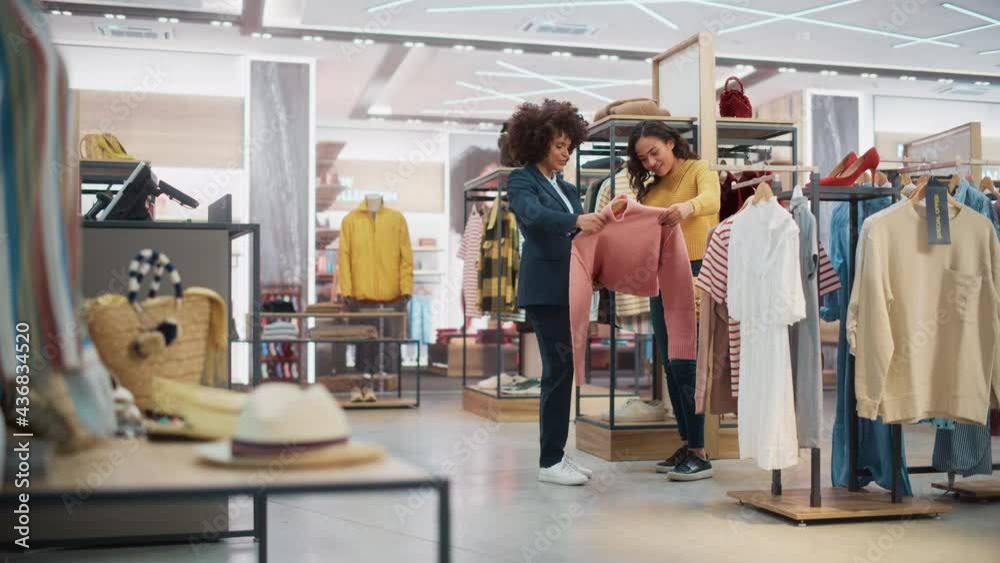 Customers Shopping in Modern Clothing Store, Retail Sales Associate Assists Client. Diverse People in Fashionable Shop, Choosing Stylish Clothes, Colorful Brand Designs, Quality Sustainable Materials.