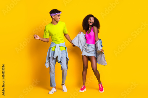 Full length body size view of attractive cheerful couple dancing good mood isolated over bright yellow color background