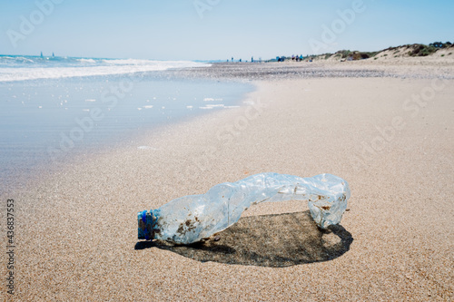 Abandoned pet plastic bottle on the shore of a clean beach, polluting the place. © Joaquin Corbalan