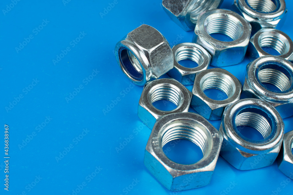 metal nuts and washers on blue background with copy space metal nuts and washers on blue background with copy space