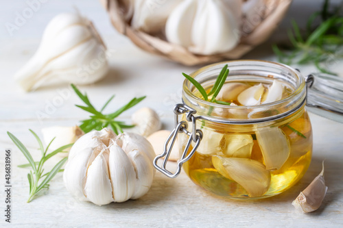 Fresh garlic and garlic oil on the wooden background photo