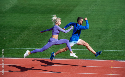 sport couple run fast to win. fitness sprinters. athletic man and sexy woman compete in sprint