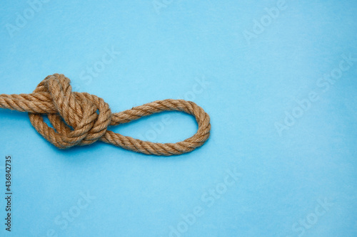 Sea shells, wooden boat and rope on a blue background.
