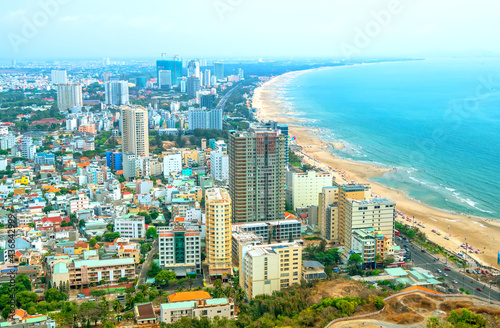 Aerial view on Vung Tau, Vietnam which is the popular beach city. There are crowded small building close to the sea and mountain. © huythoai