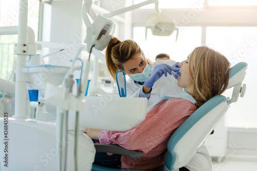 Perfect smile Female dentist is examining her beautiful patient in dentist   s office.