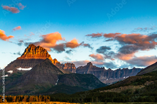 dramatic summer sunrise in Swift Current Lake in Many Glacier area in Glacier National park  with the Grinnell Mt being illuminated by the sunrise . photo