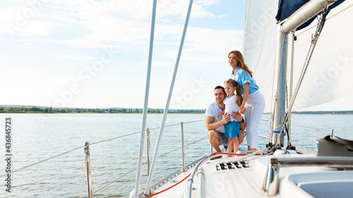 Parents And Daughter Standing On Yacht Deck On Summer Day