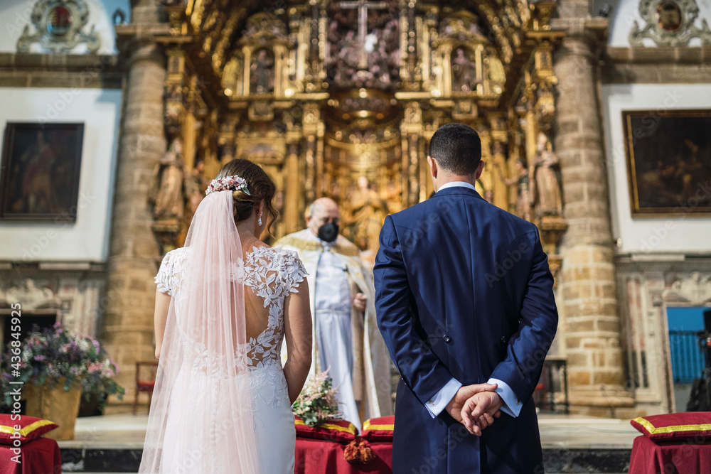 Novios ante el altar mientras se casan en una iglesia