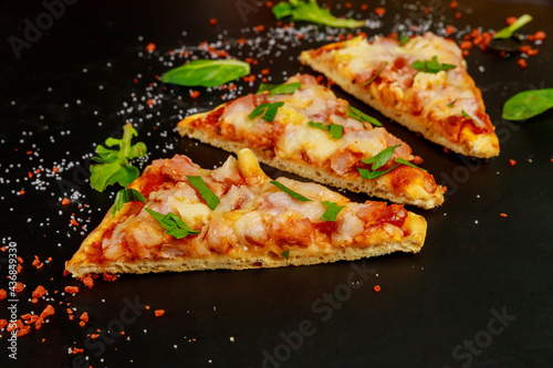 Sliced pizza with tomato sauce, ham and mozzarella .