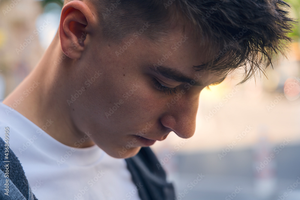 closeup of a pensive teenager looking down closeup of a pensive teenager looking down