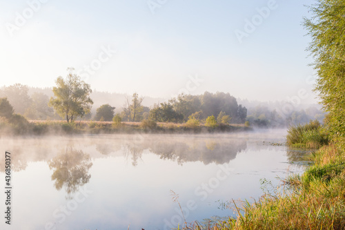 Fantastic foggy river with fresh green grass in the sunlight. Sun beams through tree. Dramatic colorful scenery. Seret river, Ternopil. Ukraine, Europe. Beauty world. photo
